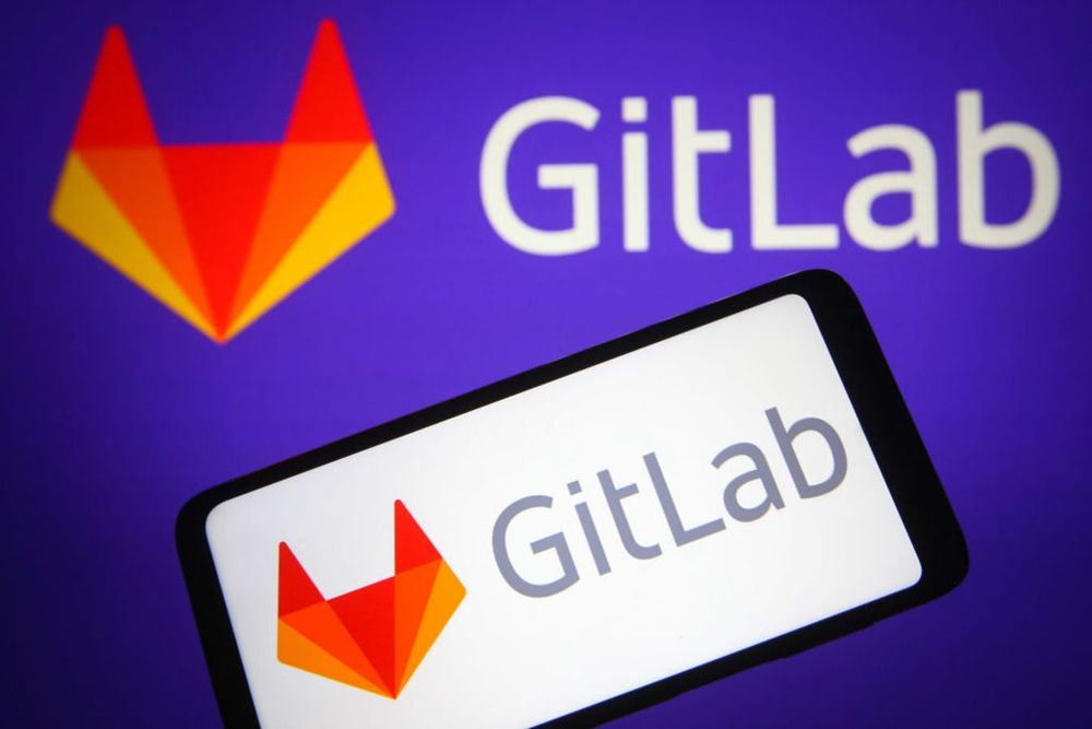  GitLab logo is seen on a smartphone and a pc screen. 