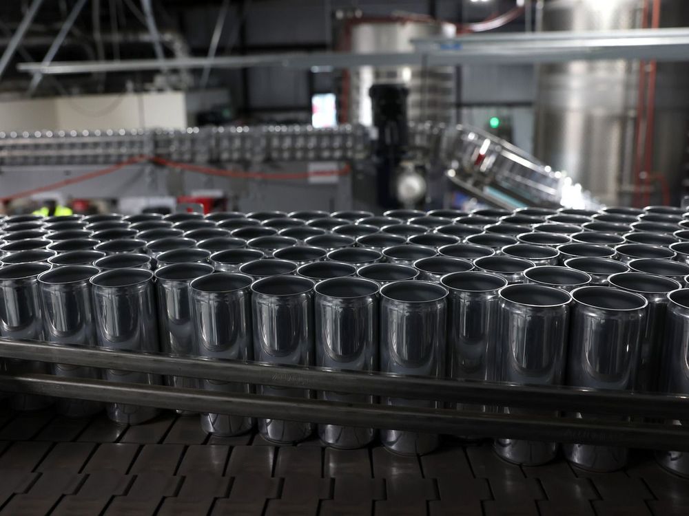 Empty aluminum cans move on an assembly line