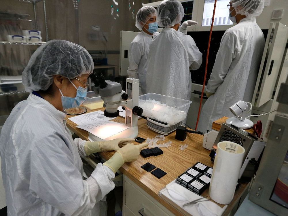 Workers use microscopes in the production facility at Applied Optoelectronics Tuesday, May 10, 2016, in Houston. (Photo by Karen Warren/Houston Chronicle via Getty Images)