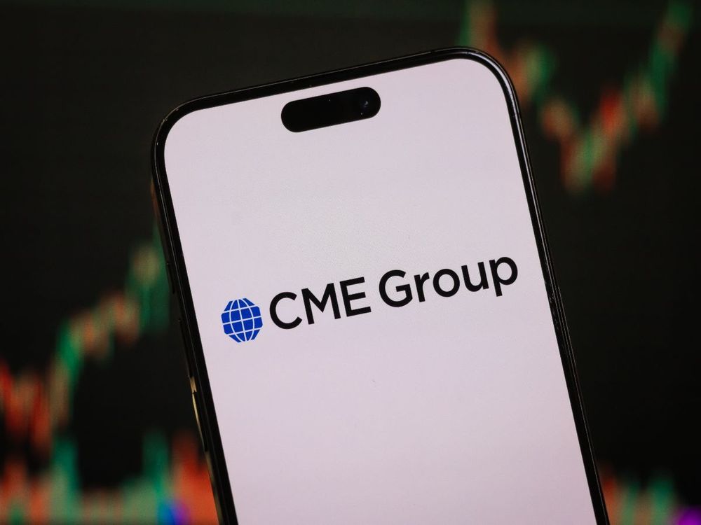 In this photo illustration, the CME Group logo is displayed on a smartphone screen in front of a stock chart showcasing CME Group's financial performance on Feb. 9, 2025, in China. (Photo illustration by Cheng Xin/Getty Images)
