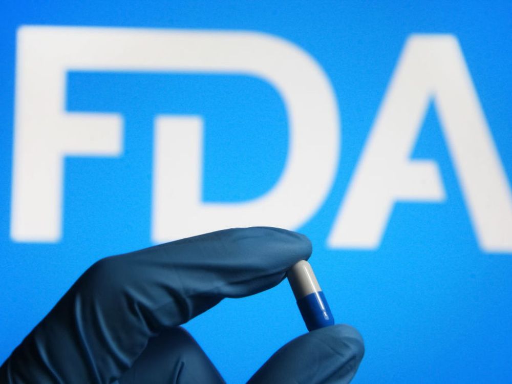 In this photo illustration, a medicine pill is seen in a hand dressed in a medical glove with the U.S. FDA logo in the background. (Photo Illustration by Pavlo Gonchar/SOPA Images/LightRocket via Getty Images) 