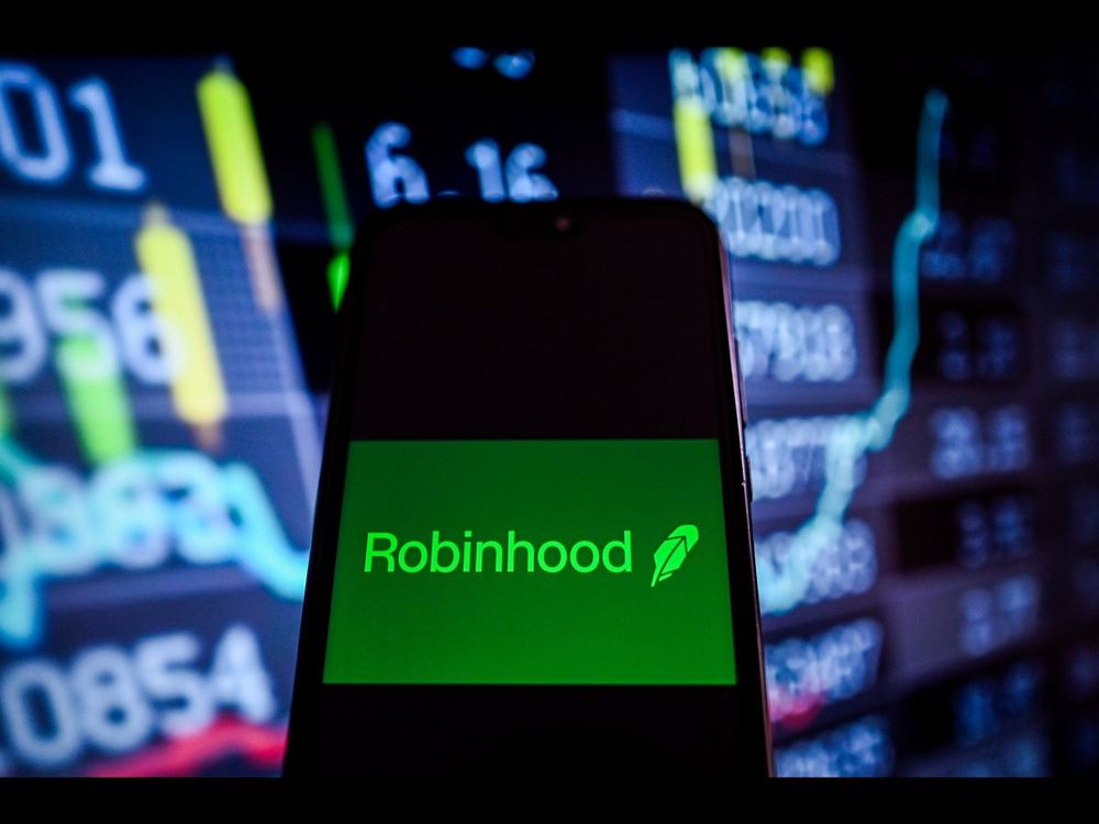In this photo illustration, a RobinHood logo is displayed on a smartphone with stock market percentages on the background. | Image Source: Omar Marques/SOPA Images/LightRocket via Getty Images