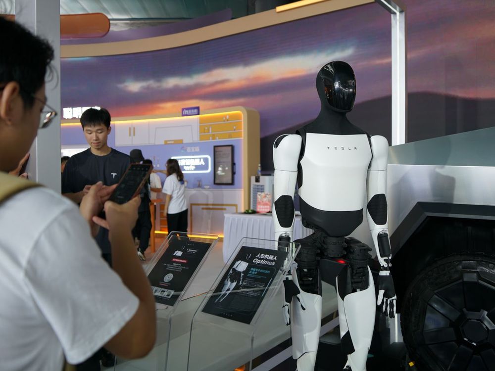 Spectators look at Tesla's Core Technology Optimus humanoid robot and a cybertruck off-road station car at the Bund Conference in Shanghai, China, September 5, 2024. (Photo: CFOTO/Future Publishing via Getty Images)