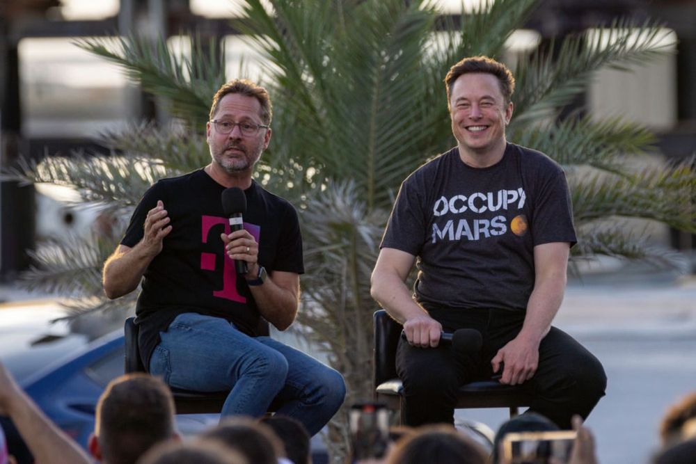 SpaceX founder Elon Musk and T-Mobile CEO Mike Sievert on stage during a T-Mobile and SpaceX joint event on August 25, 2022 in Boca Chica Beach, Texas.