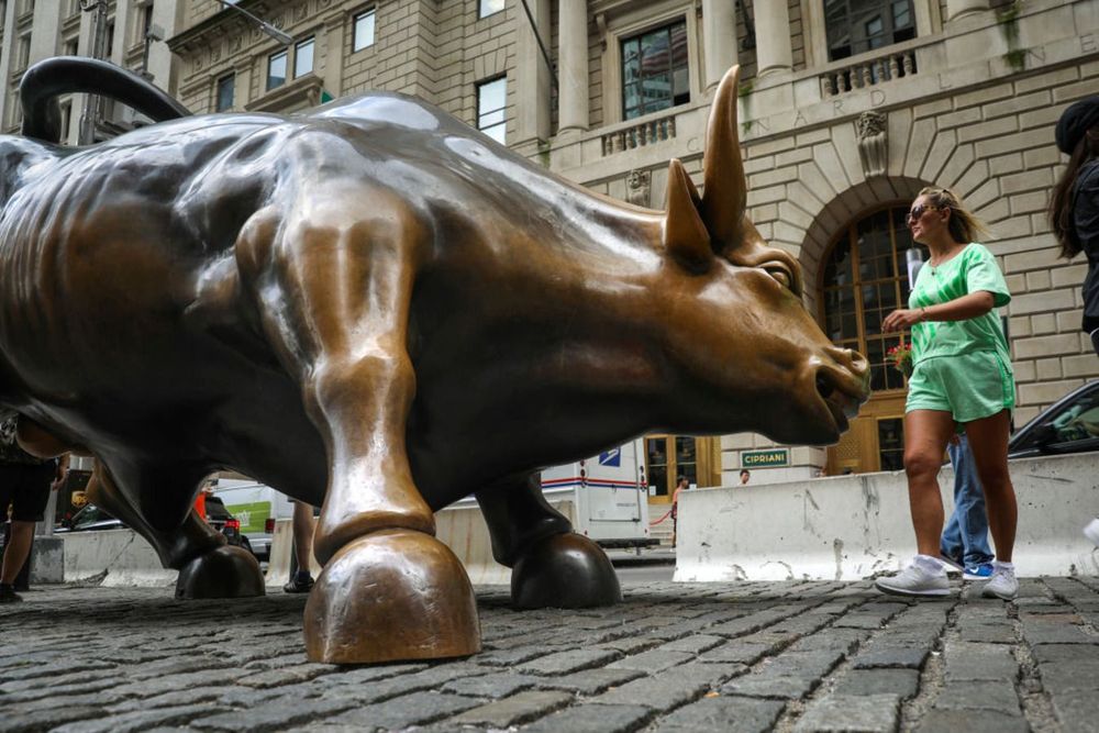Tourists visit the Wall Street bull statue in the Financial District, August 22, 2018 in New York City. 